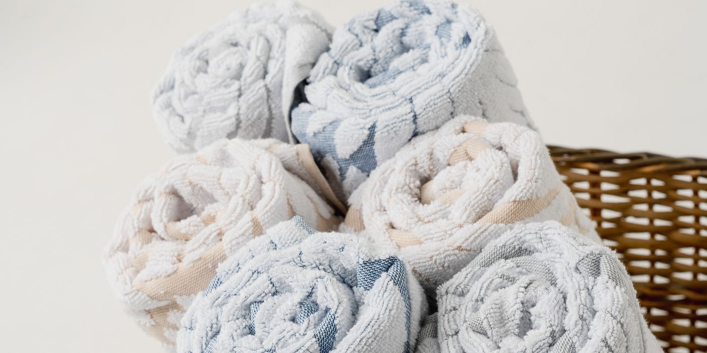 Rolled spa towels arranged in a wicker basket — soft and premium quality